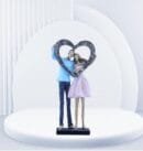 A romantic couple holding a heart-shaped sculpture, representing their affection.