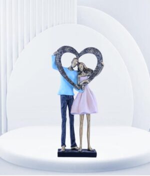 A romantic couple holding a heart-shaped sculpture, representing their affection.